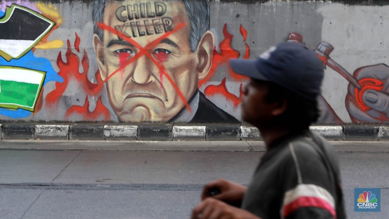 Pengendara melintas didepan mural wajah Perdana Menteri Israel Benjamin Netanyahu di Jakarta, Rabu (12/6/2024). Komunitas Berkemas membuat mural tersebut sebagai bentuk solidaritas dan dukungan kepada warga Palestina atas serangan pasukan Israel ke kota Rafah. (CNBC Indonesia/Muhammad Sabki) Pengendara melintas didepan mural wajah Perdana Menteri Israel Benjamin Netanyahu di Jakarta, Rabu (12/6/2024). Komunitas Berkemas membuat mural tersebut sebagai bentuk solidaritas dan dukungan kepada warga Palestina atas serangan pasukan Israel ke kota Rafah. (CNBC Indonesia/Muhammad Sabki)