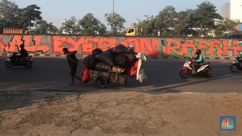 Pengendara melintas didepan mural wajah Perdana Menteri Israel Benjamin Netanyahu di Jakarta, Rabu (12/6/2024). Komunitas Berkemas membuat mural tersebut sebagai bentuk solidaritas dan dukungan kepada warga Palestina atas serangan pasukan Israel ke kota Rafah. (CNBC Indonesia/Muhammad Sabki)