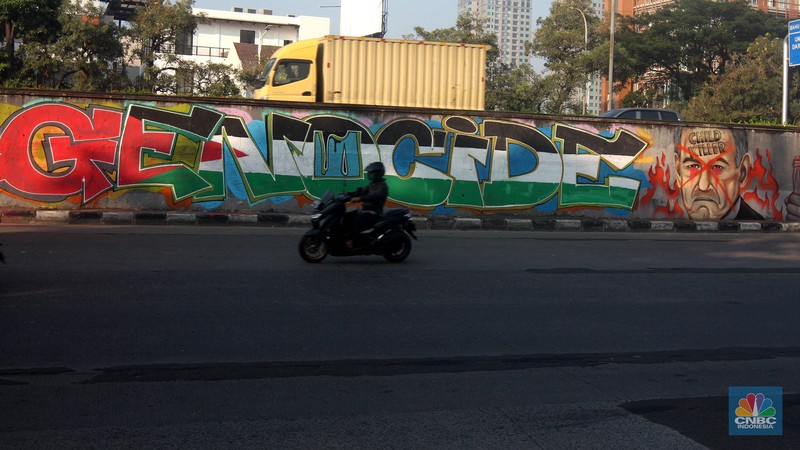 Pengendara melintas didepan mural wajah Perdana Menteri Israel Benjamin Netanyahu di Jakarta, Rabu (12/6/2024). Komunitas Berkemas membuat mural tersebut sebagai bentuk solidaritas dan dukungan kepada warga Palestina atas serangan pasukan Israel ke kota Rafah. (CNBC Indonesia/Muhammad Sabki) Pengendara melintas didepan mural wajah Perdana Menteri Israel Benjamin Netanyahu di Jakarta, Rabu (12/6/2024). Komunitas Berkemas membuat mural tersebut sebagai bentuk solidaritas dan dukungan kepada warga Palestina atas serangan pasukan Israel ke kota Rafah. (CNBC Indonesia/Muhammad Sabki)