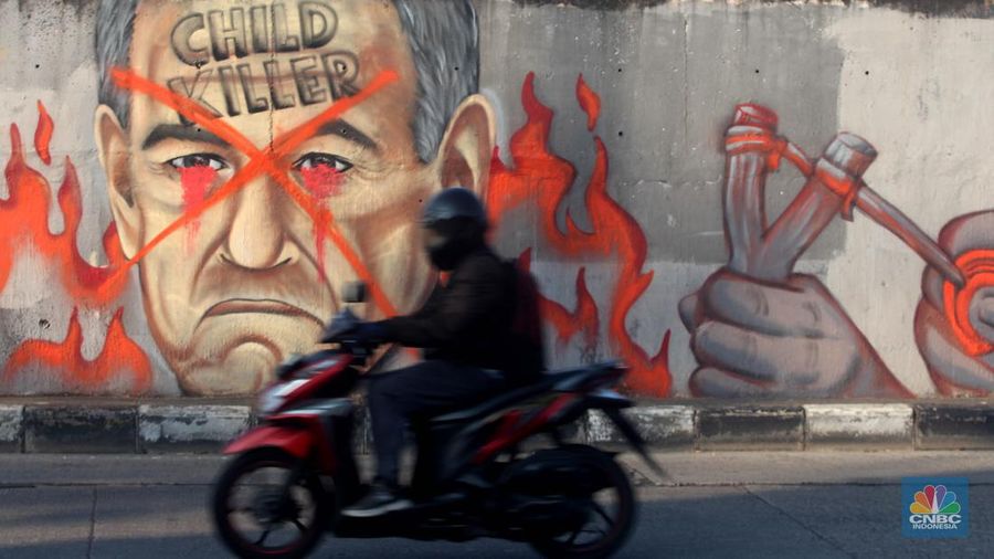 Pengendara melintas didepan mural wajah Perdana Menteri Israel Benjamin Netanyahu di Jakarta, Rabu (12/6/2024). Komunitas Berkemas membuat mural tersebut sebagai bentuk solidaritas dan dukungan kepada warga Palestina atas serangan pasukan Israel ke kota Rafah. (CNBC Indonesia/Muhammad Sabki)