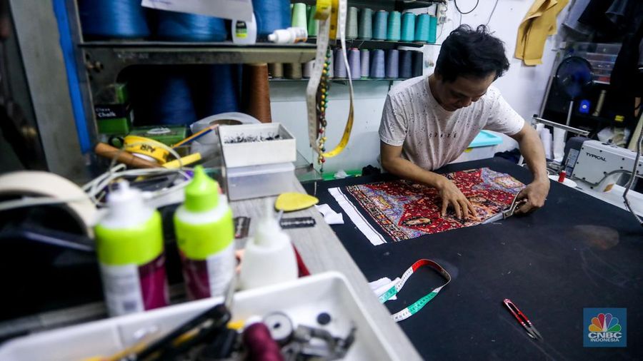 Penjahit menyelesaikan pesanan pelanggan di Pasar Santa, Jakarta, Rabu (12/6/2024). Sejumlah penjahit di Pasar Santa mengaku mengalami penurunan penghasilan hingga lebih dari 50 persen. (CNBC Indonesia/Faisal Rahman)