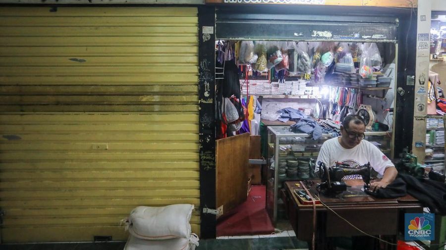 Penjahit menyelesaikan pesanan pelanggan di Pasar Santa, Jakarta, Rabu (12/6/2024). Sejumlah penjahit di Pasar Santa mengaku mengalami penurunan penghasilan hingga lebih dari 50 persen. (CNBC Indonesia/Faisal Rahman)