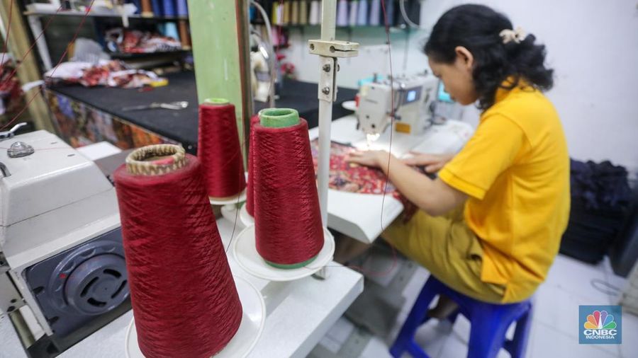 Penjahit menyelesaikan pesanan pelanggan di Pasar Santa, Jakarta, Rabu (12/6/2024). Sejumlah penjahit di Pasar Santa mengaku mengalami penurunan penghasilan hingga lebih dari 50 persen. (CNBC Indonesia/Faisal Rahman)