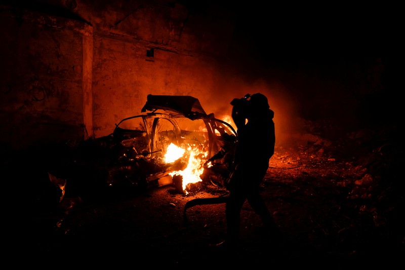 Seseorang berdiri di dekat kendaraan yang hancur, pasca serangan Israel, di Kafr Dan, dekat Jenin, di Tepi Barat yang diduduki Israel 11 Juni 2024. (REUTERS/Raneen Sawafta)