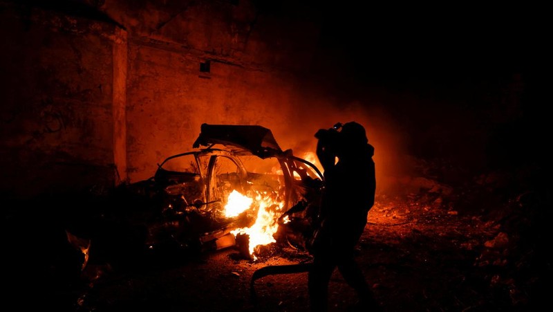 Seseorang berdiri di dekat kendaraan yang hancur, pasca serangan Israel, di Kafr Dan, dekat Jenin, di Tepi Barat yang diduduki Israel 11 Juni 2024. (REUTERS/Raneen Sawafta)