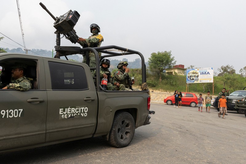 Tentara berjaga-jaga ketika orang-orang yang melarikan diri dari kekerasan geng bersenjata, yang memaksa penduduk untuk mengungsi dengan bantuan otoritas Pemerintah yang mendirikan kamp bagi para pengungsi, tiba di Yajalon, negara bagian Chiapas, Meksiko 9 Juni 2024. Tentara berjaga-jaga ketika orang-orang yang melarikan diri dari kekerasan geng bersenjata, yang memaksa penduduk untuk mengungsi dengan bantuan otoritas Pemerintah yang mendirikan kamp bagi para pengungsi, tiba di Yajalon, negara bagian Chiapas, Meksiko 9 Juni 2024. (REUTERS/Manuel Orbegozo)