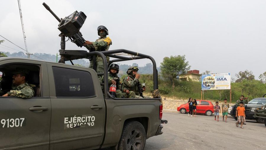 Tentara berjaga-jaga ketika orang-orang yang melarikan diri dari kekerasan geng bersenjata, yang memaksa penduduk untuk mengungsi dengan bantuan otoritas Pemerintah yang mendirikan kamp bagi para pengungsi, tiba di Yajalon, negara bagian Chiapas, Meksiko 9 Juni 2024. (REUTERS/Manuel Orbegozo)