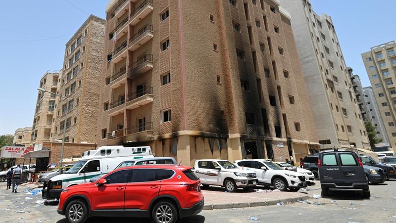 Kendaraan diparkir di samping gedung yang rusak akibat kebakaran mematikan, di Mangaf, Kuwait selatan, 12 Juni 2024. (REUTERS/Stringer)
