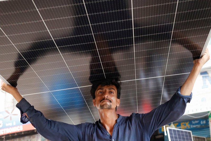 Seorang pekerja memuat panel surya ke kendaraan, di luar toko di pasar yang menjual barang-barang elektronik di Karachi, Pakistan 11 Juni 2024. Seorang pekerja memuat panel surya ke kendaraan, di luar toko di pasar yang menjual barang-barang elektronik di Karachi, Pakistan 11 Juni 2024. (REUTERS/Akhtar Soomro)