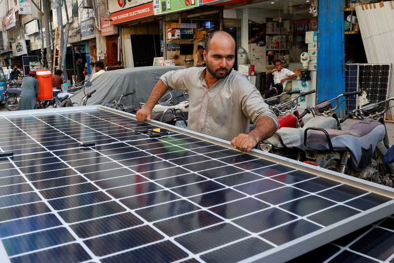 Seorang pekerja memuat panel surya ke kendaraan, di luar toko di pasar yang menjual barang-barang elektronik di Karachi, Pakistan 11 Juni 2024. Seorang pekerja memuat panel surya ke kendaraan, di luar toko di pasar yang menjual barang-barang elektronik di Karachi, Pakistan 11 Juni 2024. (REUTERS/Akhtar Soomro)