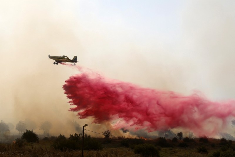 Tentara Israel berupaya memadamkan api yang membakar lahan hutan mereka setelah serangan rudal Hizbullah di pinggir jalan dekat perbatasan Israel dengan Lebanon, di Israel. (Photo by Jalaa MAREY / AFP)