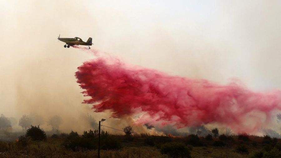 Tentara Israel berupaya memadamkan api yang membakar lahan hutan mereka setelah serangan rudal Hizbullah di pinggir jalan dekat perbatasan Israel dengan Lebanon, di Israel. (Photo by Jalaa MAREY / AFP)