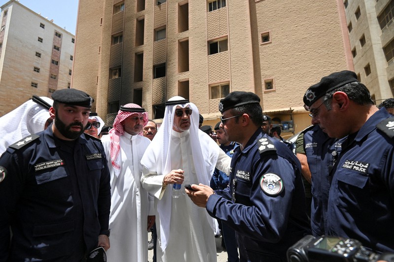 Kendaraan diparkir di samping gedung yang rusak akibat kebakaran mematikan, di Mangaf, Kuwait selatan, 12 Juni 2024. (REUTERS/Stringer)