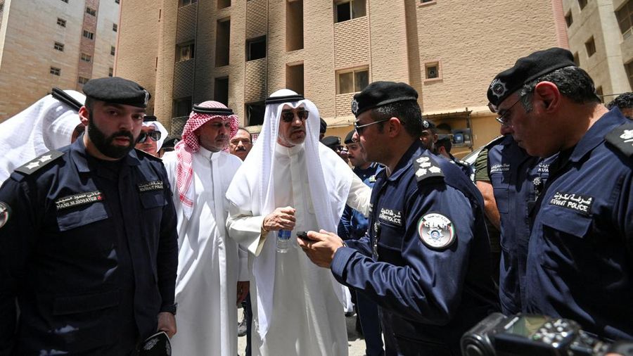 Kendaraan diparkir di samping gedung yang rusak akibat kebakaran mematikan, di Mangaf, Kuwait selatan, 12 Juni 2024. (REUTERS/Stringer)