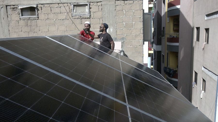 Seorang pekerja memuat panel surya ke kendaraan, di luar toko di pasar yang menjual barang-barang elektronik di Karachi, Pakistan 11 Juni 2024. (REUTERS/Akhtar Soomro)