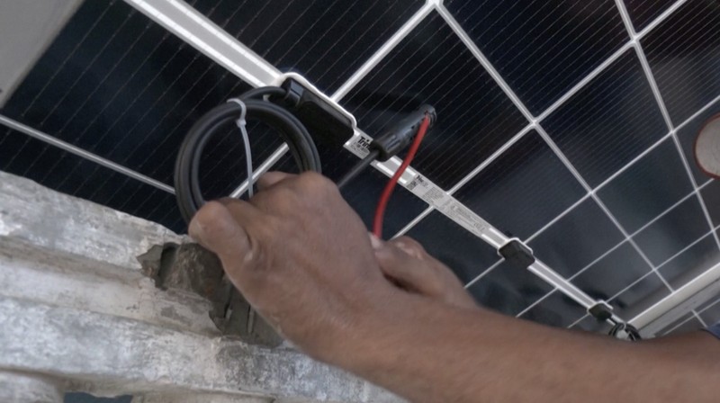 Seorang pekerja memuat panel surya ke kendaraan, di luar toko di pasar yang menjual barang-barang elektronik di Karachi, Pakistan 11 Juni 2024. (REUTERS/Akhtar Soomro)