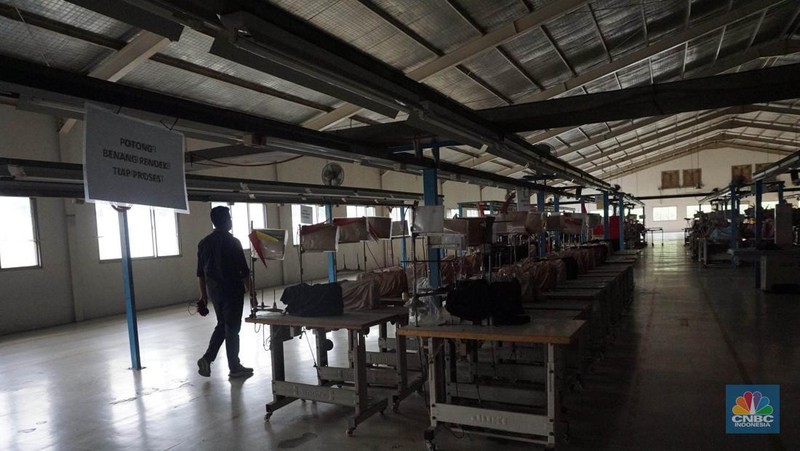 Suasana kondisi ribuan alat mesin jahit yang ditutup kain dan tidak terpakai pada salah satu pabrik garmen di kawasan Cilengsi, Kabupaten Bogor, Jawa Barat, Kamis (13/6/2024). (CNBC Indonesia/Muhammad Sabki)