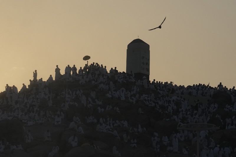 Saudi Arabia Hajj Muslim pilgrims use umbrellas to shade themselves from the sun as they gather outside Nimrah Mosque to offer the noon prayers in Arafat, on the second day of the annual hajj pilgrimage, near the holy city of Mecca, Saudi Arabia, Saturday, June 15, 2024. Masses of Muslims gathered at the sacred hill of Mount Arafat in Saudi Arabia for worship and reflection on the second day of the Hajj pilgrimage. The ritual at Mount Arafat, known as the hill of mercy, is considered the peak of the Hajj. It's often the most memorable event for pilgrims, who stand shoulder to shoulder, asking God for mercy, blessings, prosperity and good health. Hajj is one of the largest religious gatherings on earth.(AP Photo/Rafiq Maqbool)