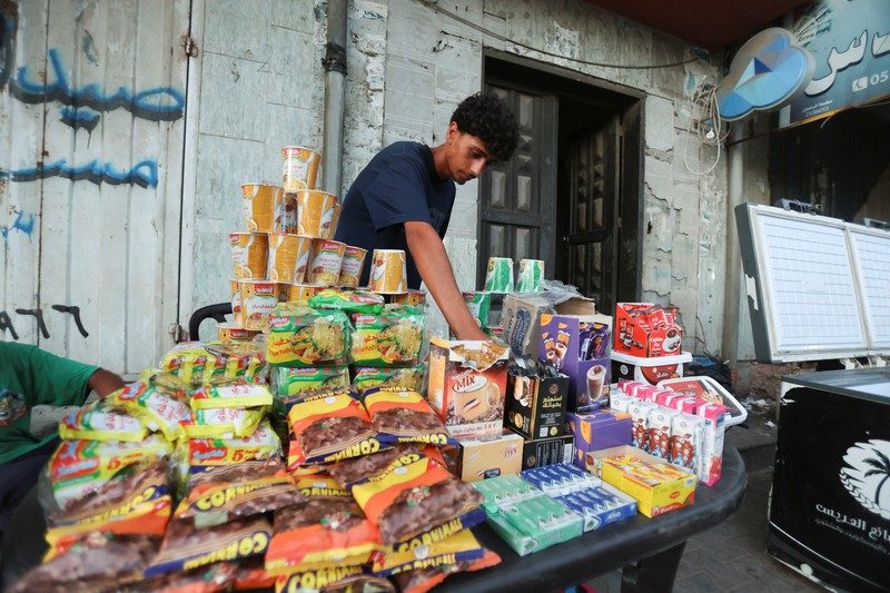 RELIGION-EID/PALESTINIANS-GAZA A Palestinian man reaches to products at a stall, ahead of Eid-al-Adha, amid the Israel-Hamas conflict, in Deir Al-Balah, in central Gaza Strip June 15, 2024. REUTERS/Ramadan Abed