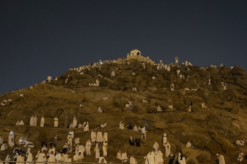 Muslim pilgrims use umbrellas to shade themselves from the sun as they gather outside Nimrah Mosque to offer the noon prayers in Arafat, on the second day of the annual hajj pilgrimage, near the holy city of Mecca, Saudi Arabia, Saturday, June 15, 2024. Masses of Muslims gathered at the sacred hill of Mount Arafat in Saudi Arabia for worship and reflection on the second day of the Hajj pilgrimage. The ritual at Mount Arafat, known as the hill of mercy, is considered the peak of the Hajj. It's often the most memorable event for pilgrims, who stand shoulder to shoulder, asking God for mercy, blessings, prosperity and good health. Hajj is one of the largest religious gatherings on earth.(AP Photo/Rafiq Maqbool)