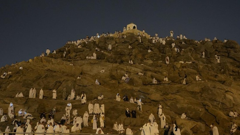 Muslim pilgrims gather at top of the rocky hill known as the Mountain of Mercy, on the Plain of Arafat, during the annual Hajj pilgrimage, near the holy city of Mecca, Saudi Arabia, Saturday, June 15, 2024. Masses of Muslims gathered at the sacred hill of Mount Arafat in Saudi Arabia for worship and reflection on the second day of the Hajj pilgrimage. The ritual at Mount Arafat, known as the hill of mercy, is considered the peak of the Hajj. It's often the most memorable event for pilgrims, who stand shoulder to shoulder, asking God for mercy, blessings, prosperity and good health. Hajj is one of the largest religious gatherings on earth. (AP Photo/Rafiq Maqbool)