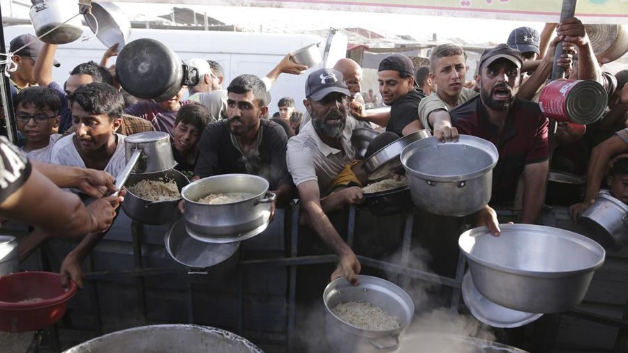CORRECTS LOCATION TO KHAN YOUNIS - A Palestinian girl reacts as she collects food aid ahead of the upcoming Eid al-Adha holiday in Khan Younis, Gaza Strip, Saturday, June 15, 2024. (AP Photo/Jehad Alshrafi)