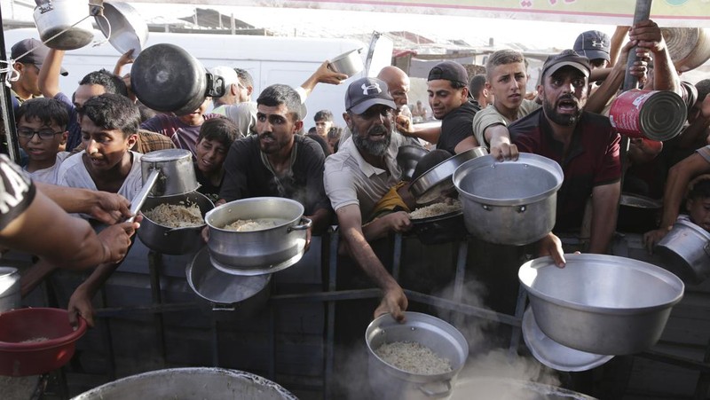 CORRECTS LOCATION TO KHAN YOUNIS - A Palestinian girl reacts as she collects food aid ahead of the upcoming Eid al-Adha holiday in Khan Younis, Gaza Strip, Saturday, June 15, 2024. (AP Photo/Jehad Alshrafi)