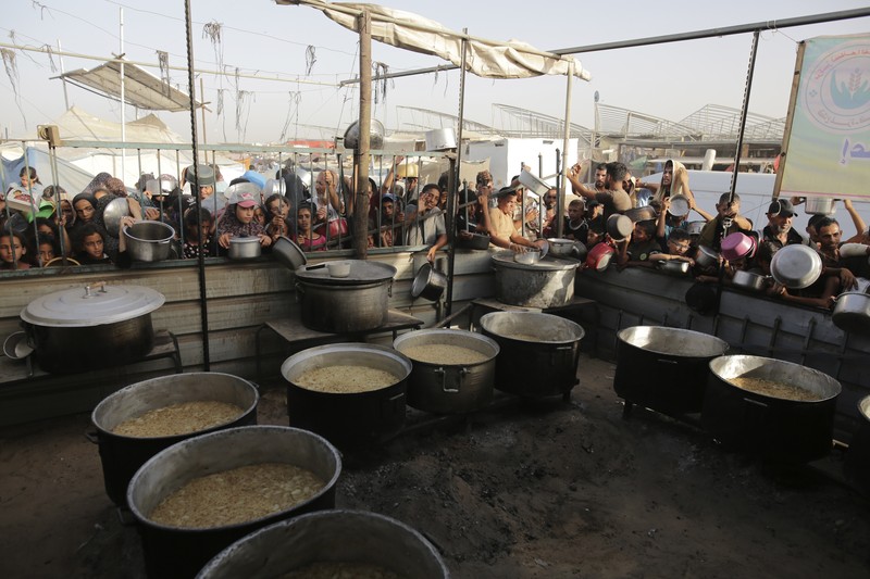 CORRECTS LOCATION TO KHAN YOUNIS - A Palestinian girl reacts as she collects food aid ahead of the upcoming Eid al-Adha holiday in Khan Younis, Gaza Strip, Saturday, June 15, 2024. (AP Photo/Jehad Alshrafi)