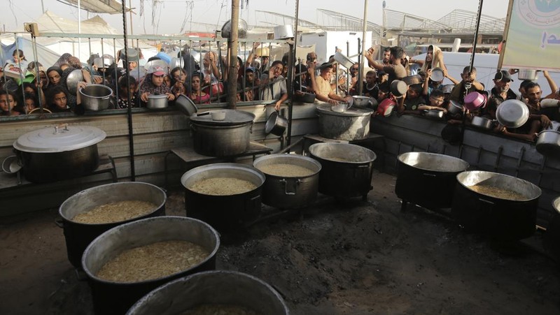 CORRECTS LOCATION TO KHAN YOUNIS - A Palestinian girl reacts as she collects food aid ahead of the upcoming Eid al-Adha holiday in Khan Younis, Gaza Strip, Saturday, June 15, 2024. (AP Photo/Jehad Alshrafi)