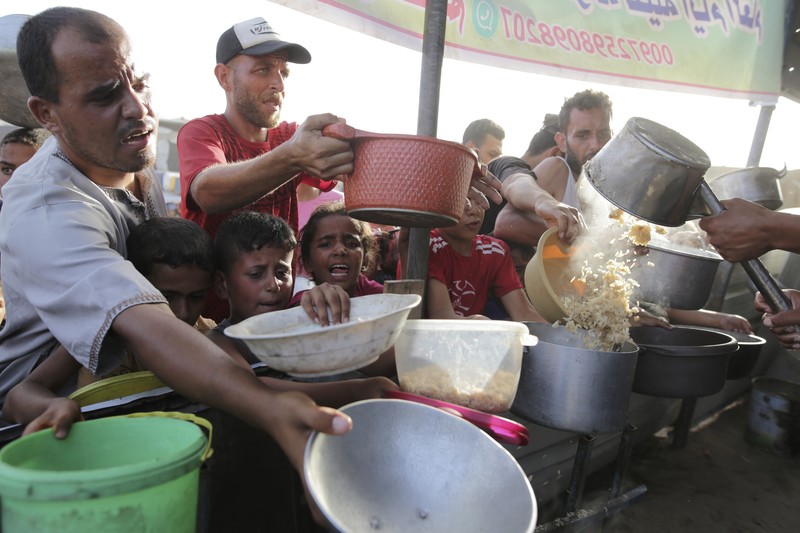 CORRECTION Israel Palestinians Eid Al-Adha CORRECTS LOCATION TO KHAN YOUNIS - A Palestinian girl reacts as she collects food aid ahead of the upcoming Eid al-Adha holiday in Khan Younis, Gaza Strip, Saturday, June 15, 2024. (AP Photo/Jehad Alshrafi)