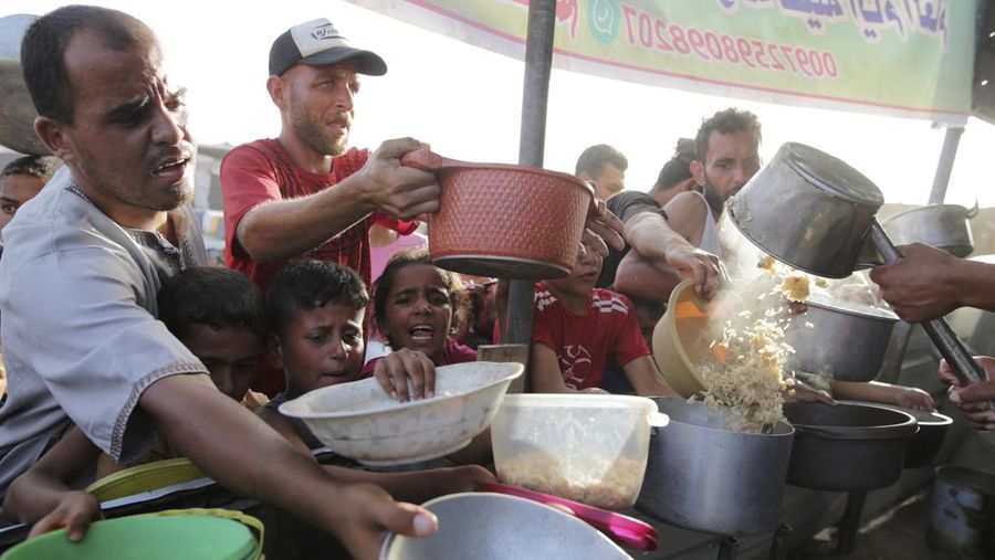 CORRECTS LOCATION TO KHAN YOUNIS - A Palestinian girl reacts as she collects food aid ahead of the upcoming Eid al-Adha holiday in Khan Younis, Gaza Strip, Saturday, June 15, 2024. (AP Photo/Jehad Alshrafi)