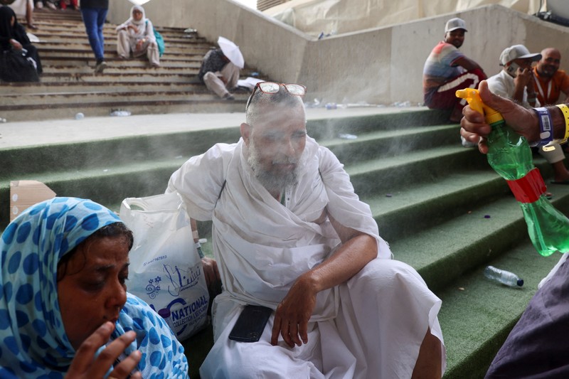 Seorang pria menutupi wajahnya menggunakan kain untuk melindungi dirinya dari sinar matahari saat dia memeriksa rel kereta api pada hari musim panas di New Delhi, India, 18 Juni 2024. (REUTERS/Priyanshu Singh)