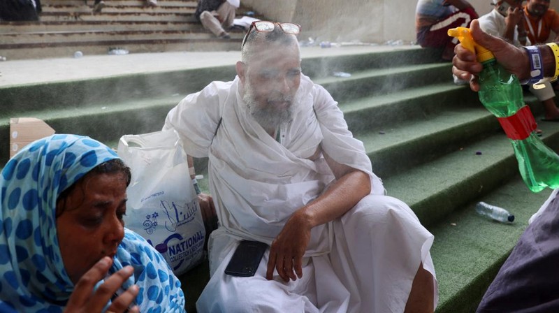 Seorang pria menutupi wajahnya menggunakan kain untuk melindungi dirinya dari sinar matahari saat dia memeriksa rel kereta api pada hari musim panas di New Delhi, India, 18 Juni 2024. (REUTERS/Priyanshu Singh)