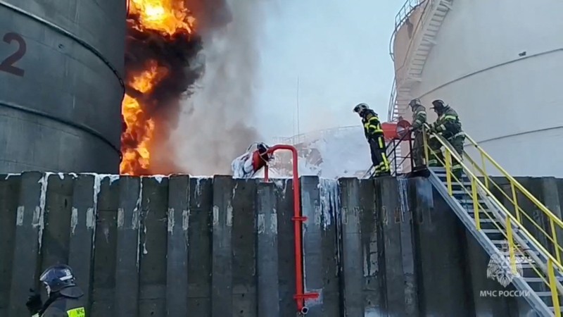 Anggota kementerian darurat Rusia bekerja untuk memadamkan api di tangki penyimpanan minyak setelah dugaan serangan pesawat tak berawak di kota Azov di wilayah selatan Rostov, Rusia, 18 Juni 2024. (Russian Emergencies Ministry/Handout via REUTERS)