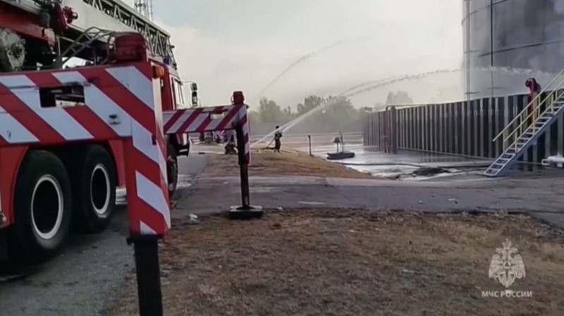 Anggota kementerian darurat Rusia bekerja untuk memadamkan api di tangki penyimpanan minyak setelah dugaan serangan pesawat tak berawak di kota Azov di wilayah selatan Rostov, Rusia, 18 Juni 2024. (Russian Emergencies Ministry/Handout via REUTERS)