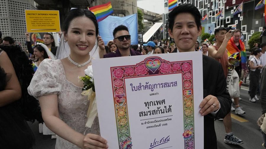 Para peserta memegang poster merayakan kesetaraan dalam pernikahan selama Parade Kebanggaan di Bangkok, Thailand, pada 1 Juni 2024. Senat Thailand memberikan suara terbanyak pada hari Selasa, 18 Juni 2024 untuk menyetujui rancangan undang-undang kesetaraan pernikahan, sehingga berhasil mengatasi hambatan legislatif terakhir yang dihadapi negara tersebut. yang pertama di Asia Tenggara yang memberlakukan undang-undang semacam itu. (AP Photo/Sakchai Lalit)