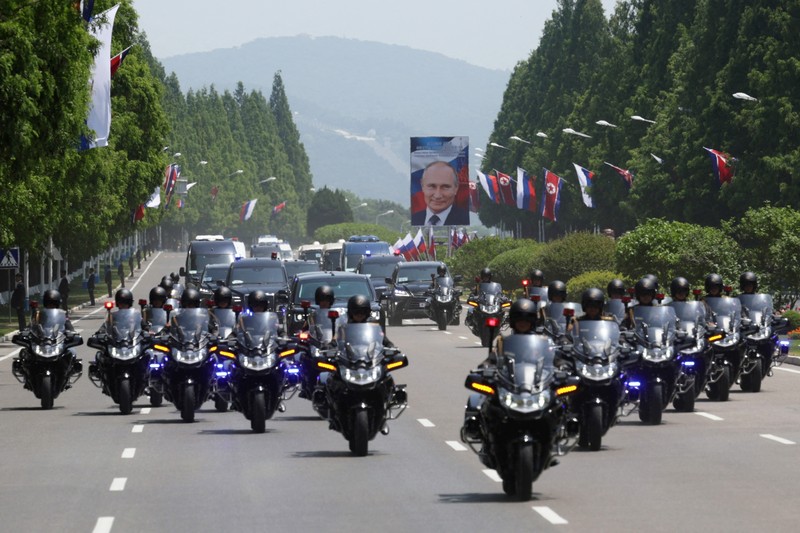 Orang-orang menyambut iring-iringan mobil Presiden Rusia Vladimir Putin di Pyongyang, Korea Utara 19 Juni 2024. (Sputnik/Gavriil Grigorov/Pool via REUTERS)