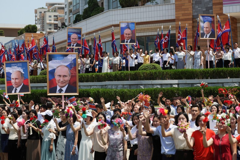 Orang-orang menyambut iring-iringan mobil Presiden Rusia Vladimir Putin di Pyongyang, Korea Utara 19 Juni 2024. (Sputnik/Gavriil Grigorov/Pool via REUTERS)
