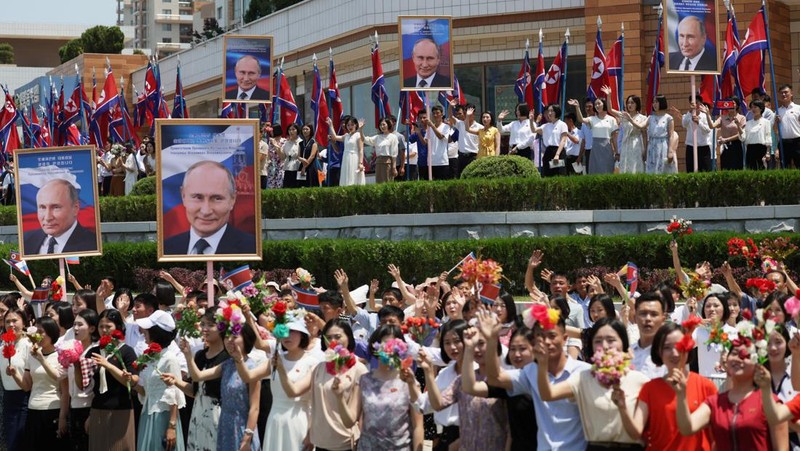 Orang-orang menyambut iring-iringan mobil Presiden Rusia Vladimir Putin di Pyongyang, Korea Utara 19 Juni 2024. (Sputnik/Gavriil Grigorov/Pool via REUTERS)