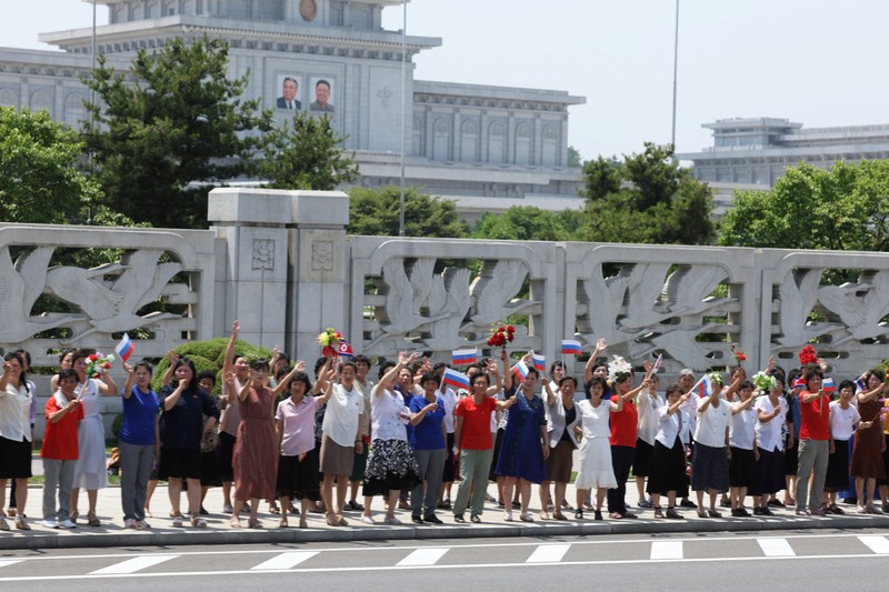 Orang-orang menyambut iring-iringan mobil Presiden Rusia Vladimir Putin di Pyongyang, Korea Utara 19 Juni 2024. (Sputnik/Gavriil Grigorov/Pool via REUTERS)