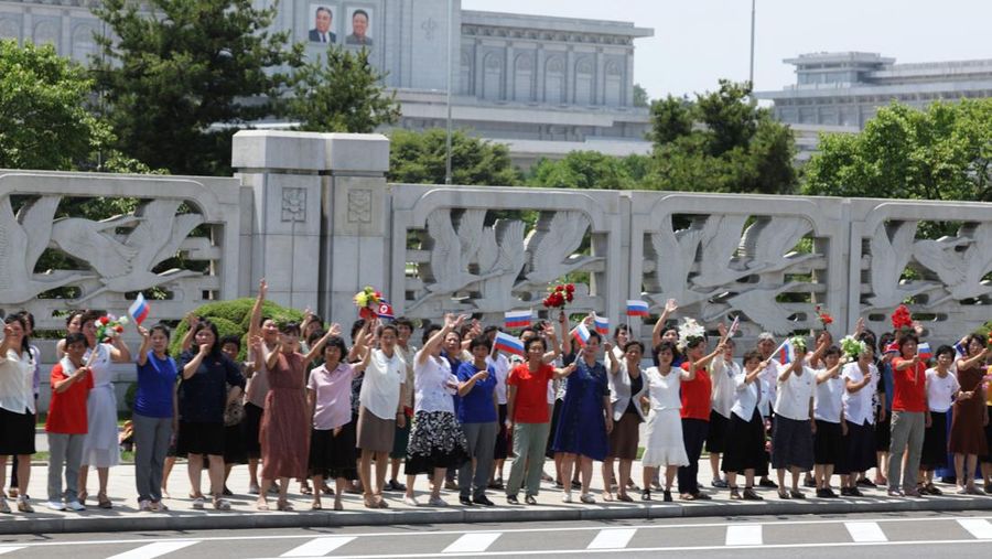 Orang-orang menyambut iring-iringan mobil Presiden Rusia Vladimir Putin di Pyongyang, Korea Utara 19 Juni 2024. (Sputnik/Gavriil Grigorov/Pool via REUTERS)