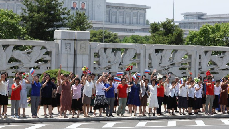 Orang-orang menyambut iring-iringan mobil Presiden Rusia Vladimir Putin di Pyongyang, Korea Utara 19 Juni 2024. (Sputnik/Gavriil Grigorov/Pool via REUTERS)