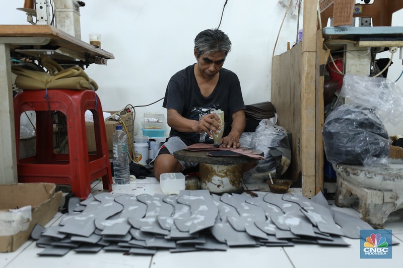 Pekerja menyelesaikan pembuatan pola alas kaki sepatu kulit di workshop Flavio Boston di kawasan Jakarta, Rabu (19/6/2024). (CNBC Indonesia/Tri Susilo)