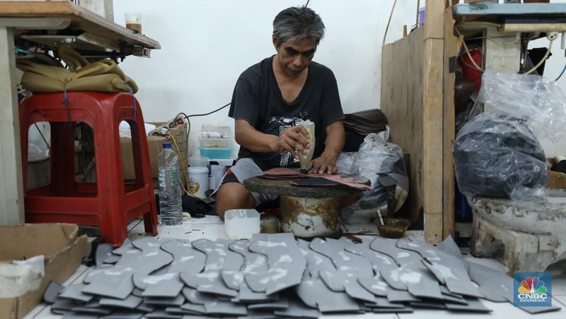 Pekerja menyelesaikan pembuatan pola alas kaki sepatu kulit di workshop Flavio Boston di kawasan Jakarta, Rabu (19/6/2024). (CNBC Indonesia/Tri Susilo)