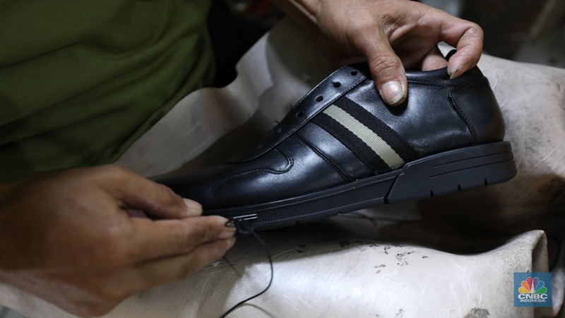 Pekerja menyelesaikan pembuatan pola alas kaki sepatu kulit di workshop Flavio Boston di kawasan Jakarta, Rabu (19/6/2024). Pekerja menyelesaikan pembuatan pola alas kaki sepatu kulit di workshop Flavio Boston di kawasan Jakarta, Rabu (19/6/2024). (CNBC Indonesia/Tri Susilo)