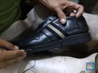 Pekerja menyelesaikan pembuatan pola alas kaki sepatu kulit di workshop Flavio Boston di kawasan Jakarta, Rabu (19/6/2024). (CNBC Indonesia/Tri Susilo)