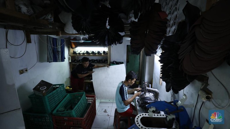 Pekerja menyelesaikan pembuatan pola alas kaki sepatu kulit di workshop Flavio Boston di kawasan Jakarta, Rabu (19/6/2024). (CNBC Indonesia/Tri Susilo)