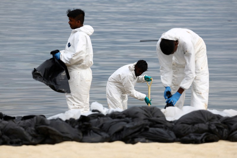 Pembersihan tumpahan minyak di Pantai Tanjong, Sentosa, Singapura, Selasa (18/6/2024). (REUTERS/Edgar Su)