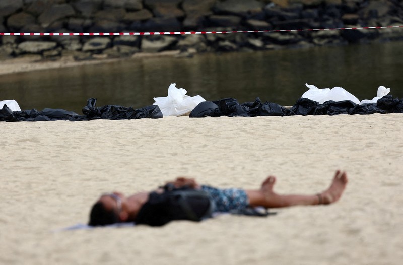 Pembersihan tumpahan minyak di Pantai Tanjong, Sentosa, Singapura, Selasa (18/6/2024). (REUTERS/Edgar Su) Pembersihan tumpahan minyak di Pantai Tanjong, Sentosa, Singapura, Selasa (18/6/2024). (REUTERS/Edgar Su)