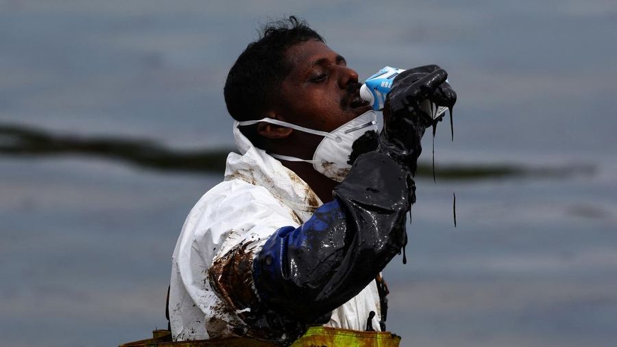 Pembersihan tumpahan minyak di Pantai Tanjong, Sentosa, Singapura, Selasa (18/6/2024). (REUTERS/Edgar Su)